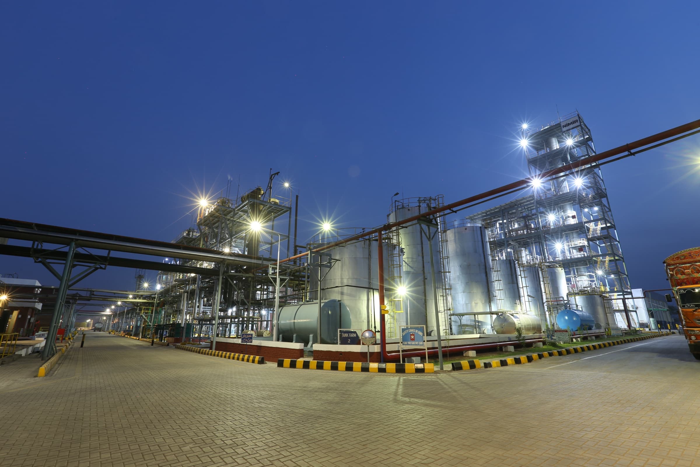 Industrial manufacturing complex at twilight, lit and powered through the night